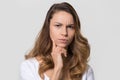 Puzzled perplexed woman with frowning face isolated on studio wall