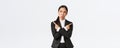 Puzzled pretty asian businesswoman in black suit troubled making choice, standing indecisive, pointing fingers sideways Royalty Free Stock Photo
