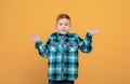 Puzzled school boy showing confusion, yellow background