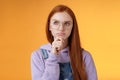 Puzzled serious-looking smart young redhead girl confused thinking deep focus problem touch chin frowning look upper Royalty Free Stock Photo