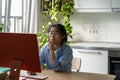 Concentrated Asian woman in glasses using computer web surfing in internet at home Royalty Free Stock Photo
