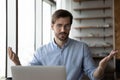 Puzzled worried businessman concerned about problems with laptop