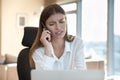 Puzzled worried freelance worker talking on mobile phone at workplace