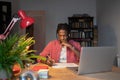 Puzzled young black man make note touch chin work on difficult research project use laptop at desk. Royalty Free Stock Photo