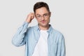 Puzzled Caucasian man in glasses isolated on grey background Royalty Free Stock Photo