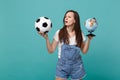 Puzzled young girl football fan support favorite team with soccer ball, Earth world globe isolated on blue turquoise