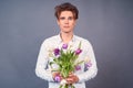 Sad young guy after a bad date, with a spoiled hairdo and a broken bouquet of flowers Royalty Free Stock Photo