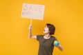 Puzzled young protesting woman hold protest sign broadsheet placard on stick Earth world globe isolated on yellow