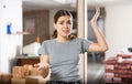 Puzzled young woman examining her house during renovation