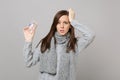 Puzzled young woman in gray sweater, scarf putting hand on head hold daily pill box isolated on grey background. Healthy