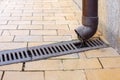 Pvc downpipe rainwater system with a drainage grate. Royalty Free Stock Photo