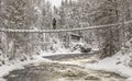 Pwerson on a hanging bridge in a winter landscape
