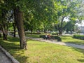Pyatigorsk, Russia - August 19, 2022: People are sitting on a park bench. Tall chestnut trees grow along the alley