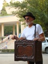 Man in a white t-shirt and a black hat with a barrel organ in Tsvetnik Park in Pyatigorsk, Russia Royalty Free Stock Photo