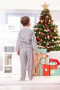 Pyjama boy with toy at christmas tree