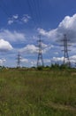 Pylons of high-voltage power transmission lines on a summer field Royalty Free Stock Photo