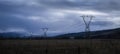 Pylons and power cables under stormy dark clouds, Central Otago, South Island