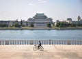 09/09/2018: Pyongyang, North-Korea: a lonely cyclist passing Kim Il Sung Palace Royalty Free Stock Photo