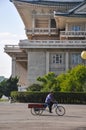 Pyongyang, North-Korea, 09/07/2018: a lonely haul bike is passing by the cultural palace of the people.