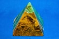 Pyramid of onyx stone on a blue background.