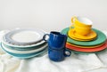 A pyramid of brightly colored bowls, plates and cups of different sizes and colors on the kitchen table. Scandinavian Royalty Free Stock Photo