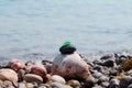 The pyramid is built on a pebble beach of sea pebbles with a matte smooth green glass at the top. Against the background of waves