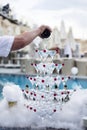 Pyramid of champagne glasses and cocktail cherries in clouds of artificial smoke