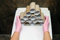 Pyramid of empty toilet paper rolls and hands in protective gloves, close-up Royalty Free Stock Photo