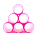 Pyramid made of pink hair curlers on white Royalty Free Stock Photo