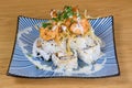 Pyramid of maki roll with fried shrimps, tempura vegetables, sesame and rocket decoration