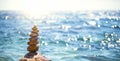 A pyramid of pebbles on a large stone against the background of the sea and the sun`s glare on the water. Tour, tourism, vacation Royalty Free Stock Photo