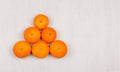 Pyramid of ripe mandarines on grey background