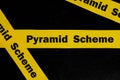 Pyramid scheme alert, caution and warning concept. Yellow barricade tape with word scam in dark black background. Royalty Free Stock Photo