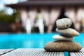 Pyramid of sea pebbles on the edge of the pool and against the background of gazebos for relaxation. The concept of life balance Royalty Free Stock Photo