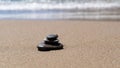 Stone meditation on sand beach. Balance stones near the sea. Concept of harmony, stability, life balance, relaxation Royalty Free Stock Photo