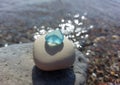 Pyramid of sea stones with piece of blue glass on top