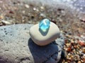 Pyramid of sea stones with piece of blue glass on top