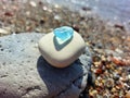 Pyramid of sea stones with piece of blue glass on top