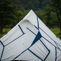A pyramid-shaped tent with a modern design features angular blue geometric patterns Royalty Free Stock Photo
