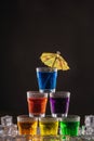 Pyramid of shots with colorful alcohol, decorated with umbrellas for cocktails