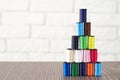 Pyramid of spools of multi-colored sewing threads on the table