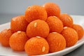 Pyramid Stack of Motichoor Ladoos on White Plate with Almond Garnish and Neutral Background Royalty Free Stock Photo