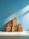 A pyramid stack of various sized plain cardboard shipping boxes arranged neatly against a vibrant blue wall with natural sunlight Royalty Free Stock Photo