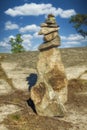 A pyramid of stones on a background of a blue sky with clouds Royalty Free Stock Photo