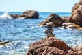 Pyramid stones balance on the sand of the beach. Blue Sea on Background Selective focus, zen stones on sea beach, meditation, spa Royalty Free Stock Photo