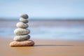 Pyramid stones balance on the sand of the beach. The object is in focus