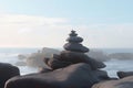 Pyramid stones balance on the sand of the beach. The object is in focus, the background is blurred. Neural network AI Royalty Free Stock Photo