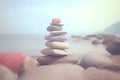 Pyramid stones balance on the sand of the beach. The object is in focus, the background is blurred. Neural network AI Royalty Free Stock Photo