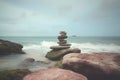 Pyramid stones balance on the sand of the beach. The object is in focus, the background is blurred. Neural network AI Royalty Free Stock Photo