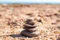 Pyramid of stones laid out on a sandy sea beach, selective focus. Relaxation and balance Royalty Free Stock Photo